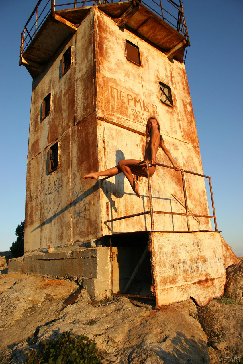 Naked Inna K spreads wide on rusty tower above mountain valley